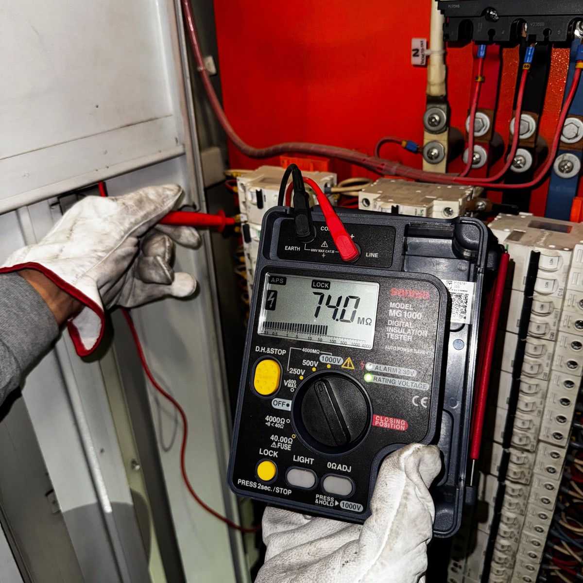 Prueba de aislamiento con megóhmetro en un tablero eléctrico, con la lectura de 74,0 MΩ en pantalla.